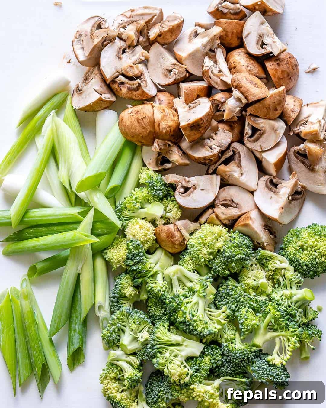 Vibrant Sweet and Sour Vegetable Stir-Fry 5 Prepped cremini mushrooms, broccoli florets, and sliced green onions for stir fry.