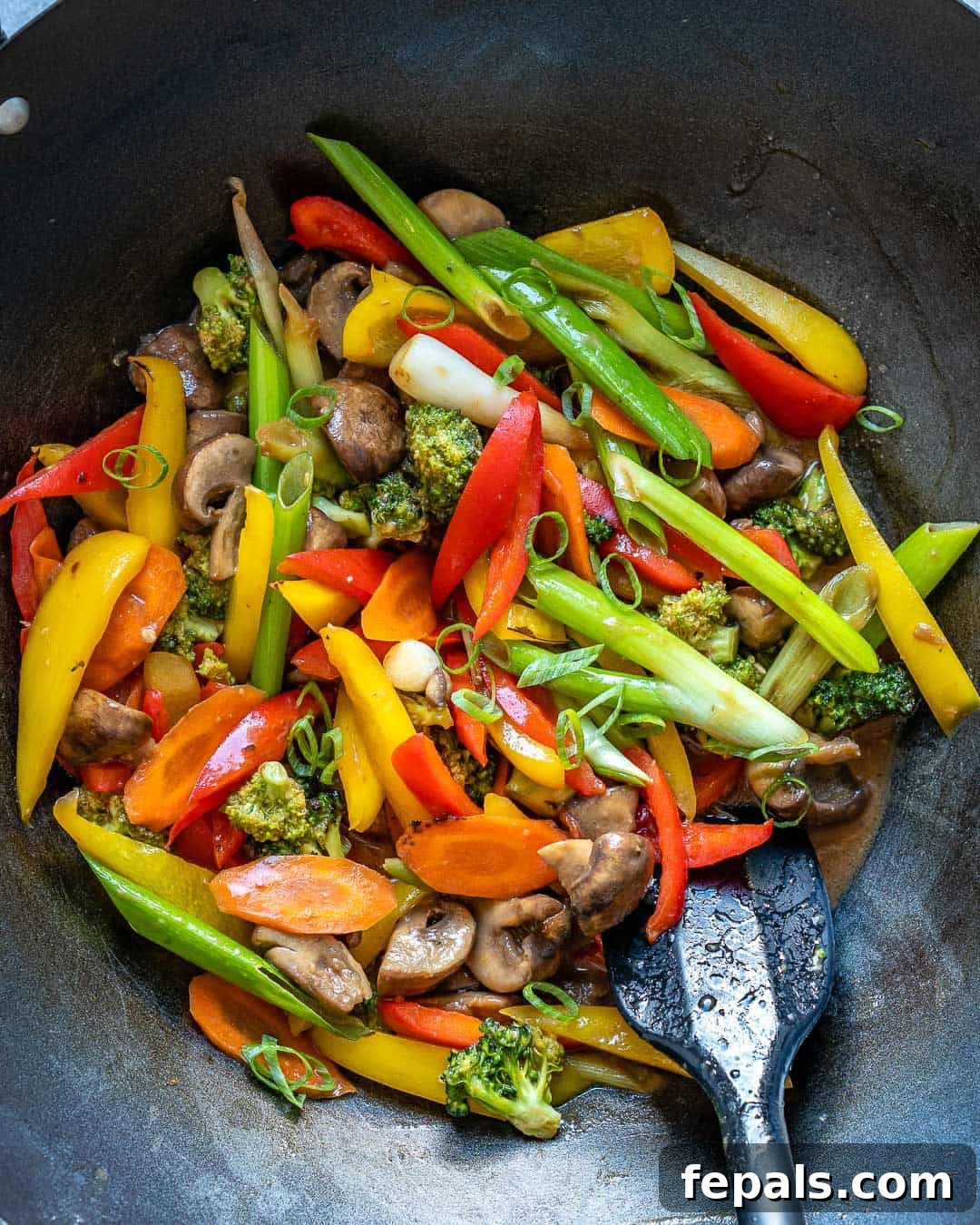 Vibrant Sweet and Sour Vegetable Stir-Fry 7 A mix of colorful vegetables being stir-fried in a wok on a stovetop.