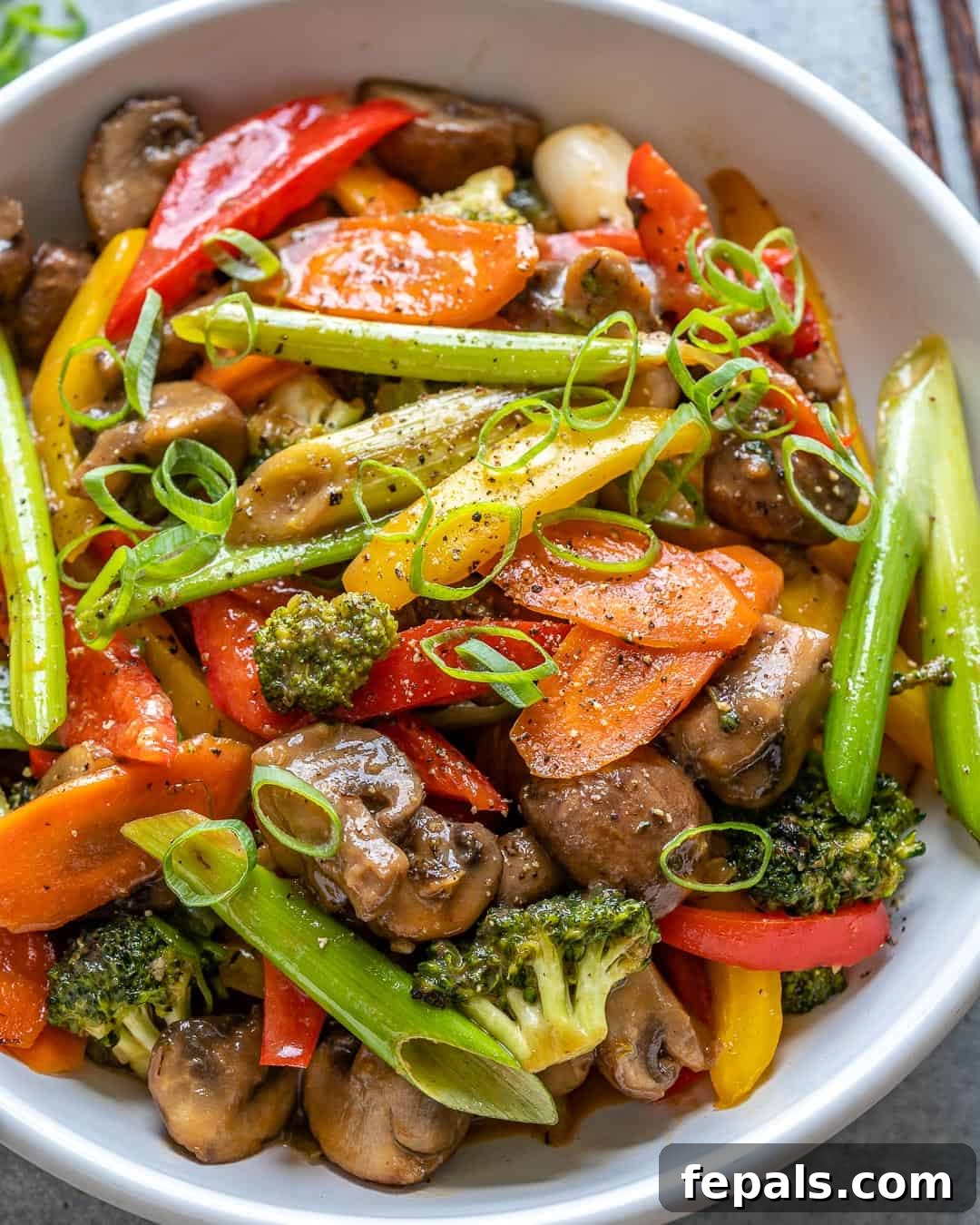 Vibrant Sweet and Sour Vegetable Stir-Fry 9 A white bowl filled with sweet and sour vegetable stir fry, viewed from the side, slightly cropped.