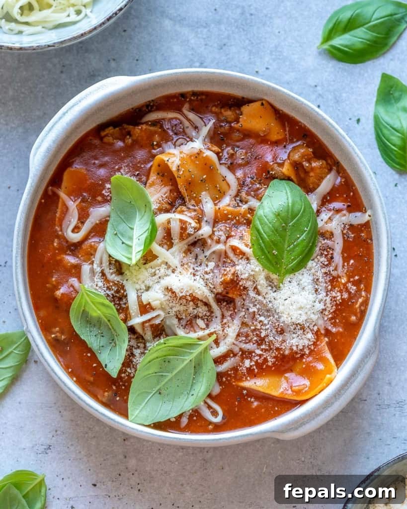 Comforting One Pot Lasagna Soup 10 top view of soup in white bowl with basil leaves garnishes