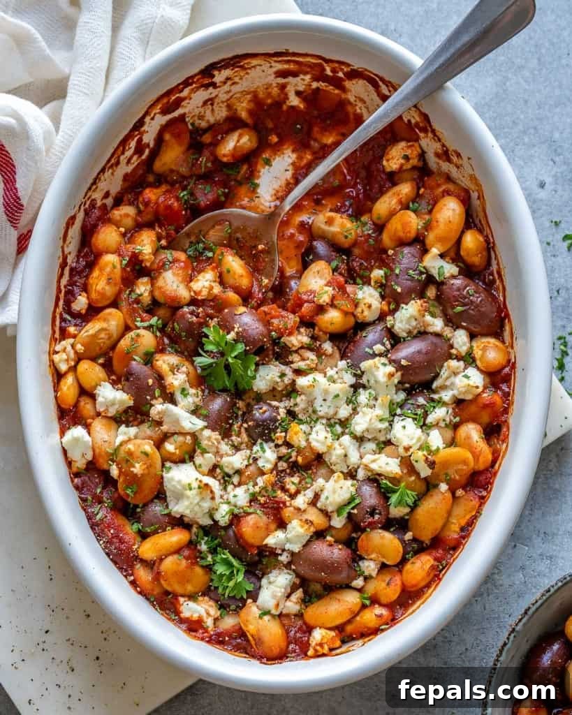 Gigantes Plaki 8 Top view of a baking dish of Greek Baked Beans with a spoon, showing the creamy texture and rich color.