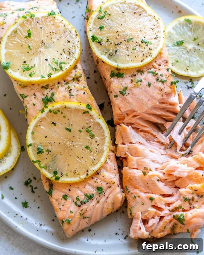 two baked salmon on plate with fork flaking it