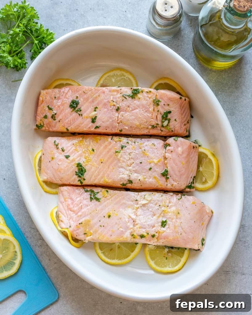raw marinated salmon in a white dish ready to be baked
