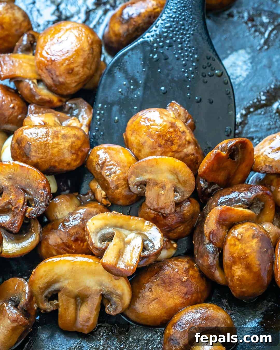 Cooked sliced mushrooms in a skillet, lightly browned.