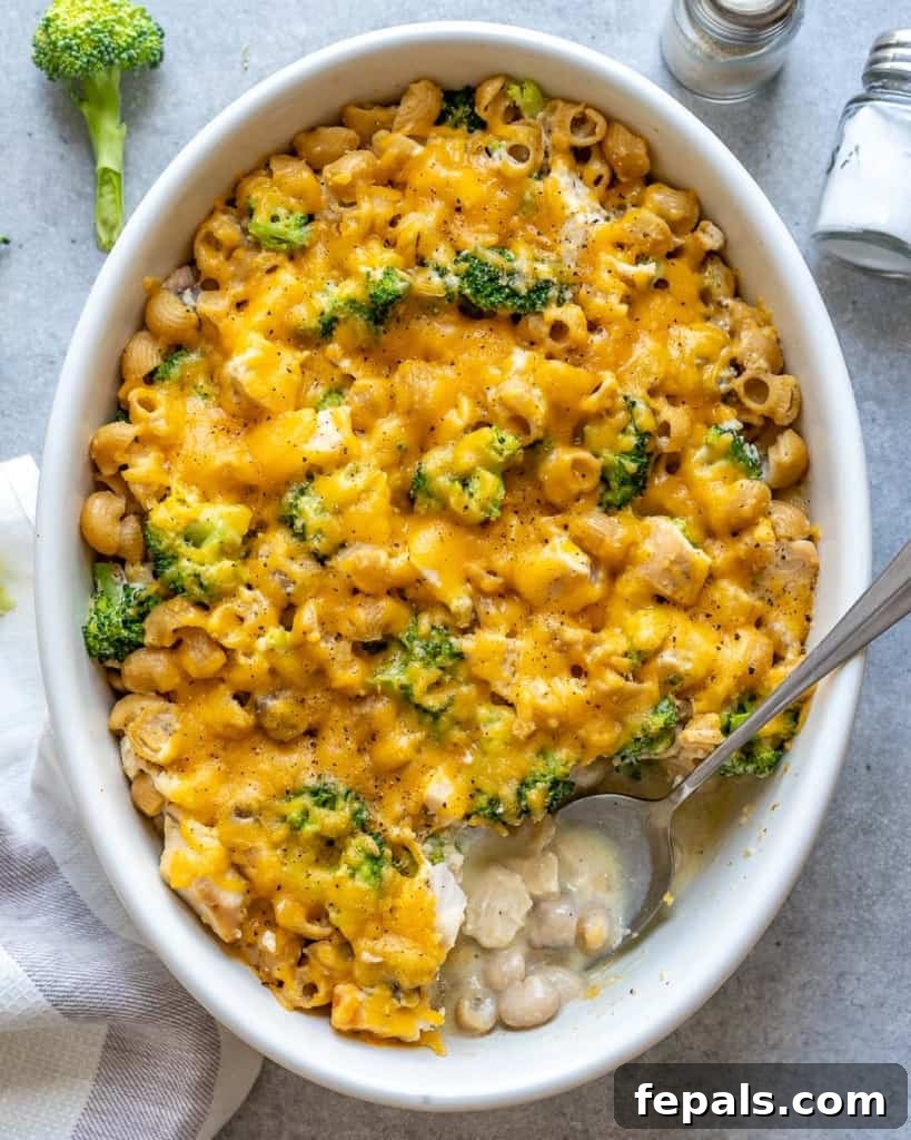 A top-down view of a generous serving of broccoli chicken casserole with a spoon, highlighting its creamy texture and rich ingredients.