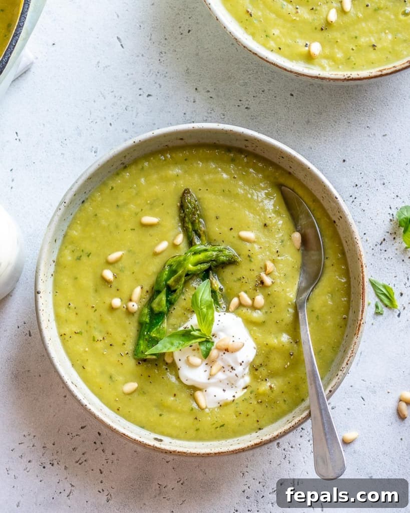 Velvet Asparagus Soup 3 top view of spoon in asparagus soup with greek yogurt granish