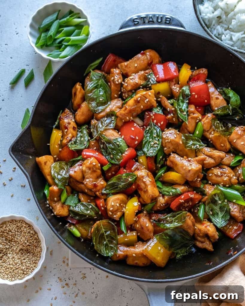 Sizzling Thai Basil Chicken stir-fry in a cast iron skillet, ready to serve.