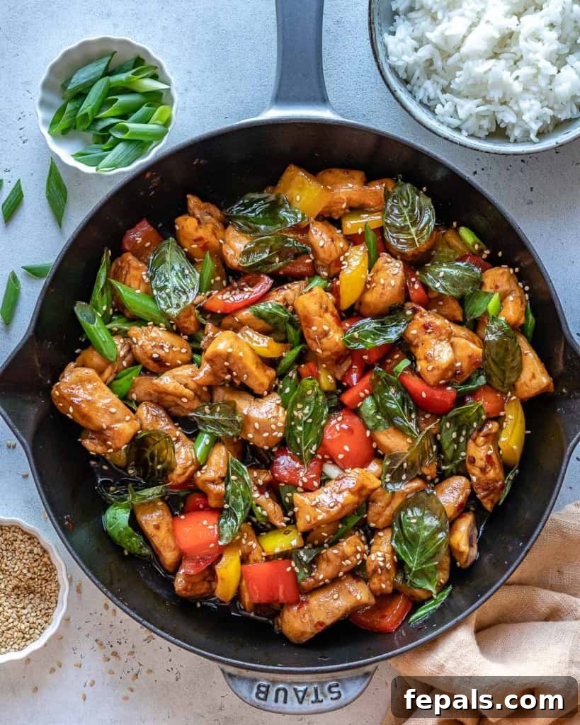 Thai basil chicken stir-fry served directly from a black skillet.
