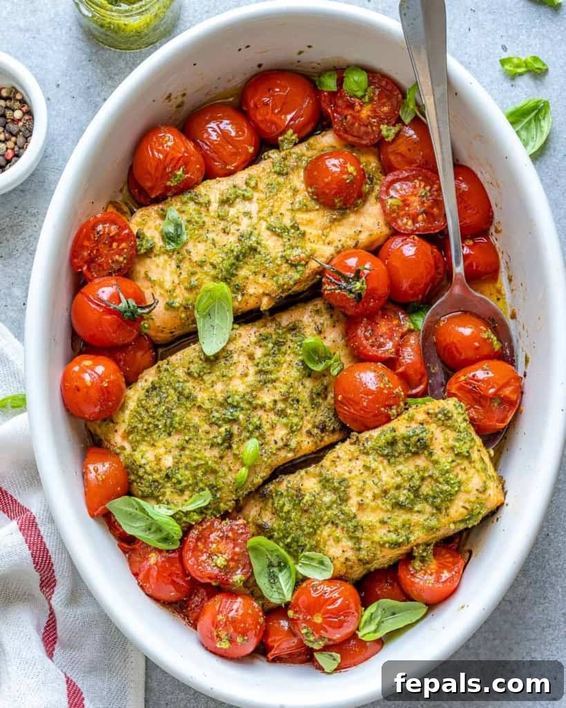 top view of spoon in baked salmon and tomatoes 