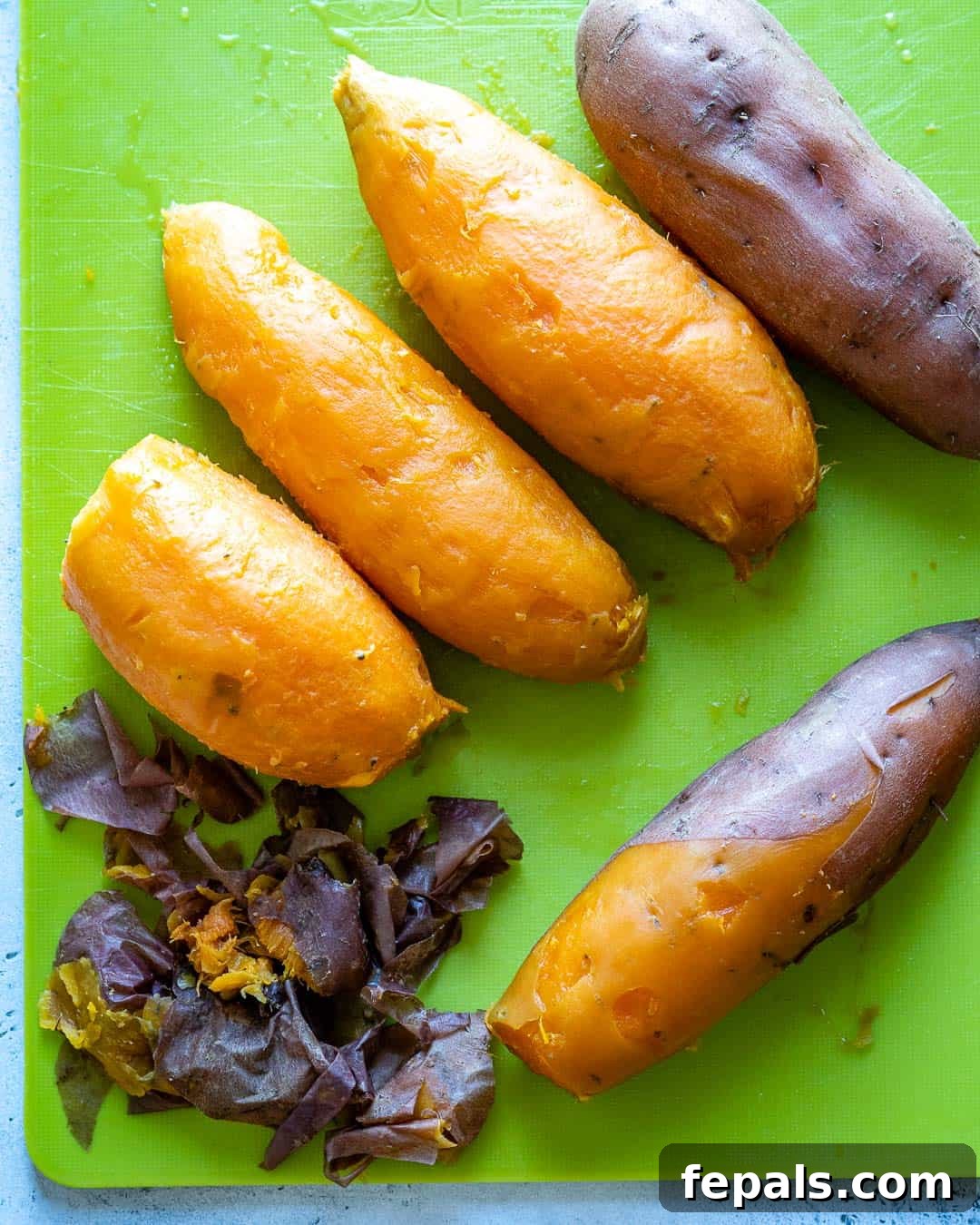 Velvety Sweet Potato Mash 5 Fresh, whole sweet potatoes, carefully peeled and ready for the next step in the mashing process, showcasing their vibrant orange flesh.