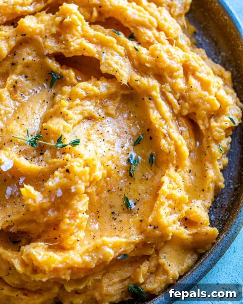 Velvety Sweet Potato Mash 8 A close-up of rich, creamy mashed sweet potatoes, perfectly prepared and ready to be served, showcasing their vibrant color and inviting texture.