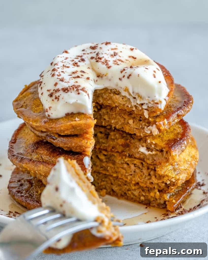 pancakes stacks with yogurt topping and a bite cut out with fork