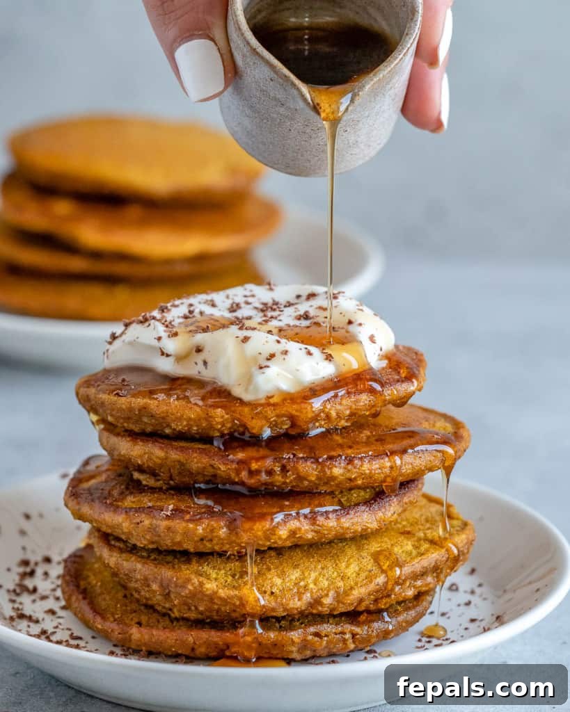 maple syrup being poured over pancakes