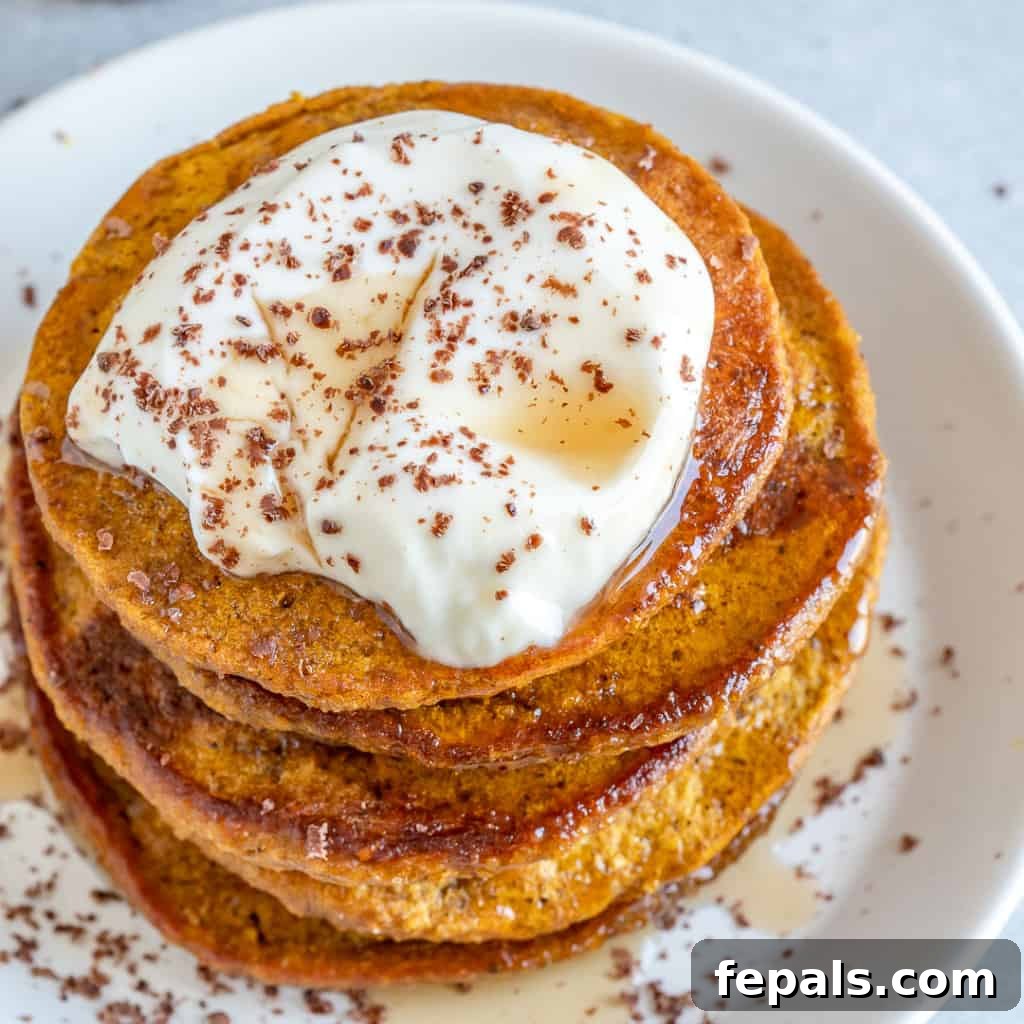 top view of pumpkin pancakes topped with yogurt maple syrup and cinnamon