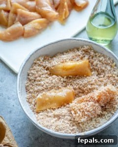Crispy Air Fryer Chicken Nuggets 9 Close view of chicken being coated in breadcrumbs.