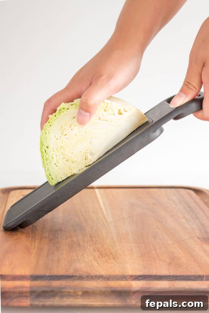 Mastering Cabbage Cuts 11 hand holding cabbage over mandolin