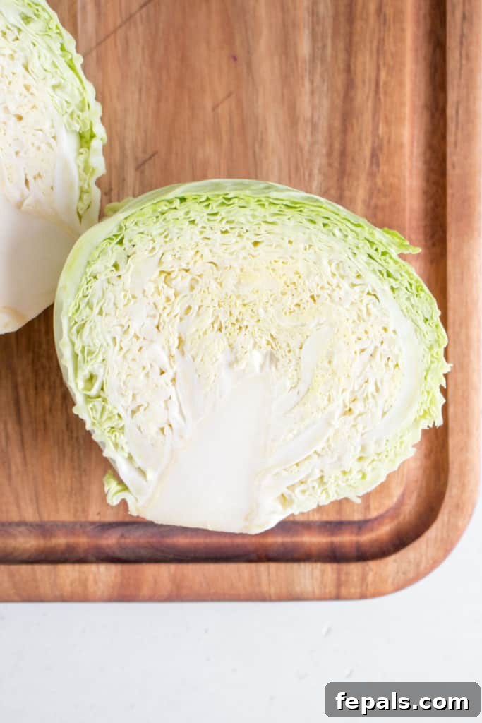 Mastering Cabbage Cuts 6 top view of green cabbage cut in half on a cutting board