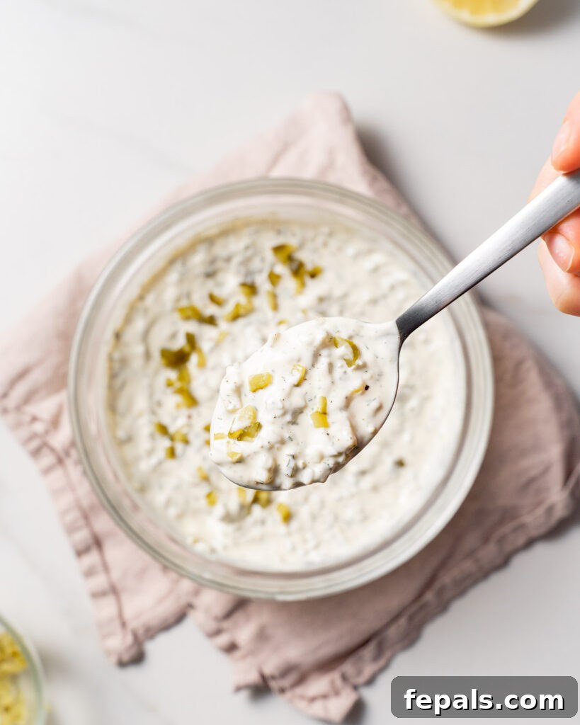 spoonful of tartar sauce over a bowl 