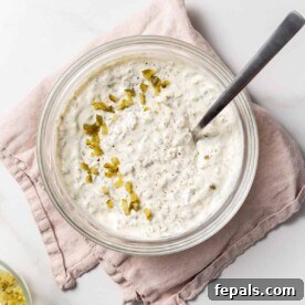 tartar sauce in a clear bowl with a spoon in the bowl.