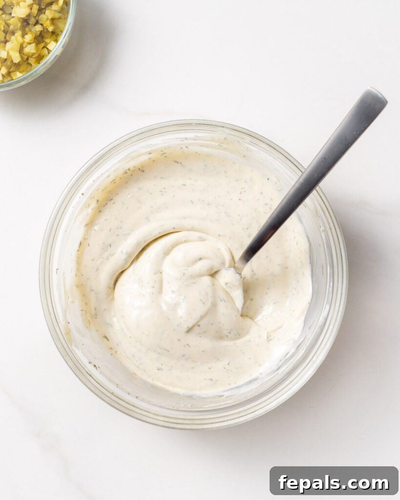 ingredients to make tartar sauce in a bowl mixed with a spoon