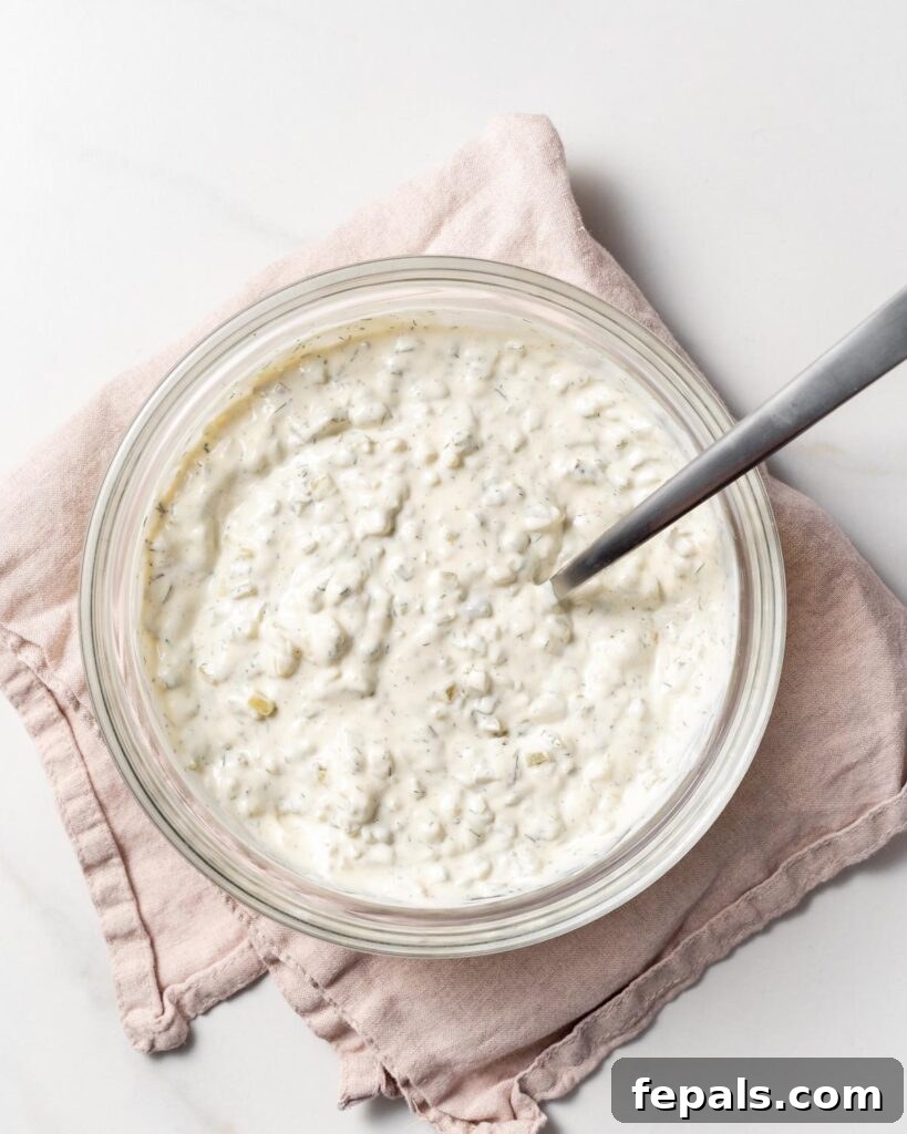 spoon in bowl of tartar sauce after it was mixed