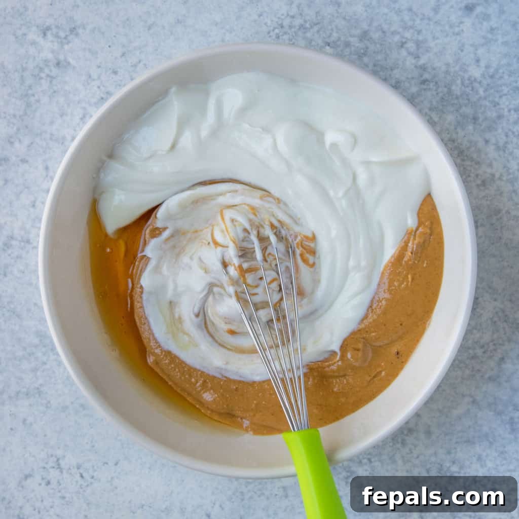 Peanut Butter Bliss Dip 10 3 ingredients, yogurt, honey, and peanut butter in white bowl