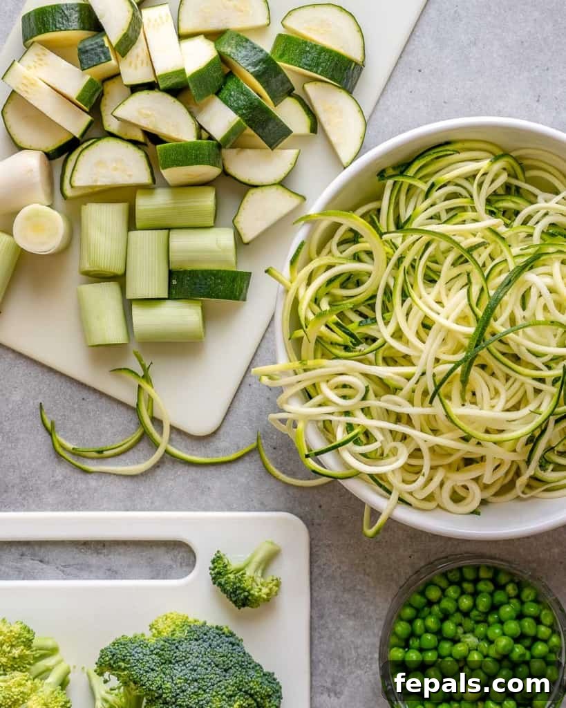 chopped and zoodled zucchini on a board