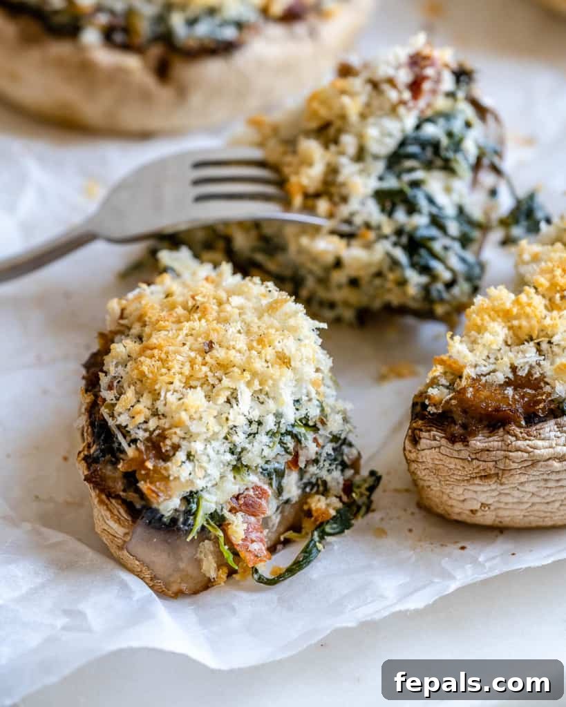 Rustic Tuscan Stuffed Mushrooms 12 A close-up image of a perfectly cooked and sliced stuffed mushroom, with a fork poised to take a bite, highlighting its tempting interior.