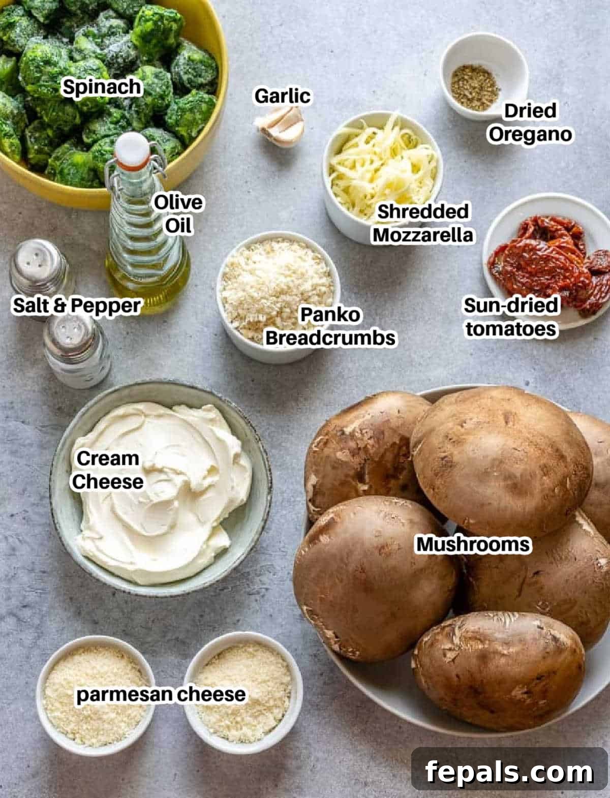 Rustic Tuscan Stuffed Mushrooms 4 A colorful array of ingredients laid out on a wooden board, including fresh portobello mushrooms, spinach, sun-dried tomatoes, and various cheeses, ready for preparation.