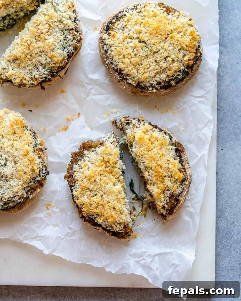 Rustic Tuscan Stuffed Mushrooms 9 A close-up, top-down view of a stuffed mushroom cut in half, revealing its rich, creamy, and textured filling with spinach and sun-dried tomatoes, ready to be enjoyed.