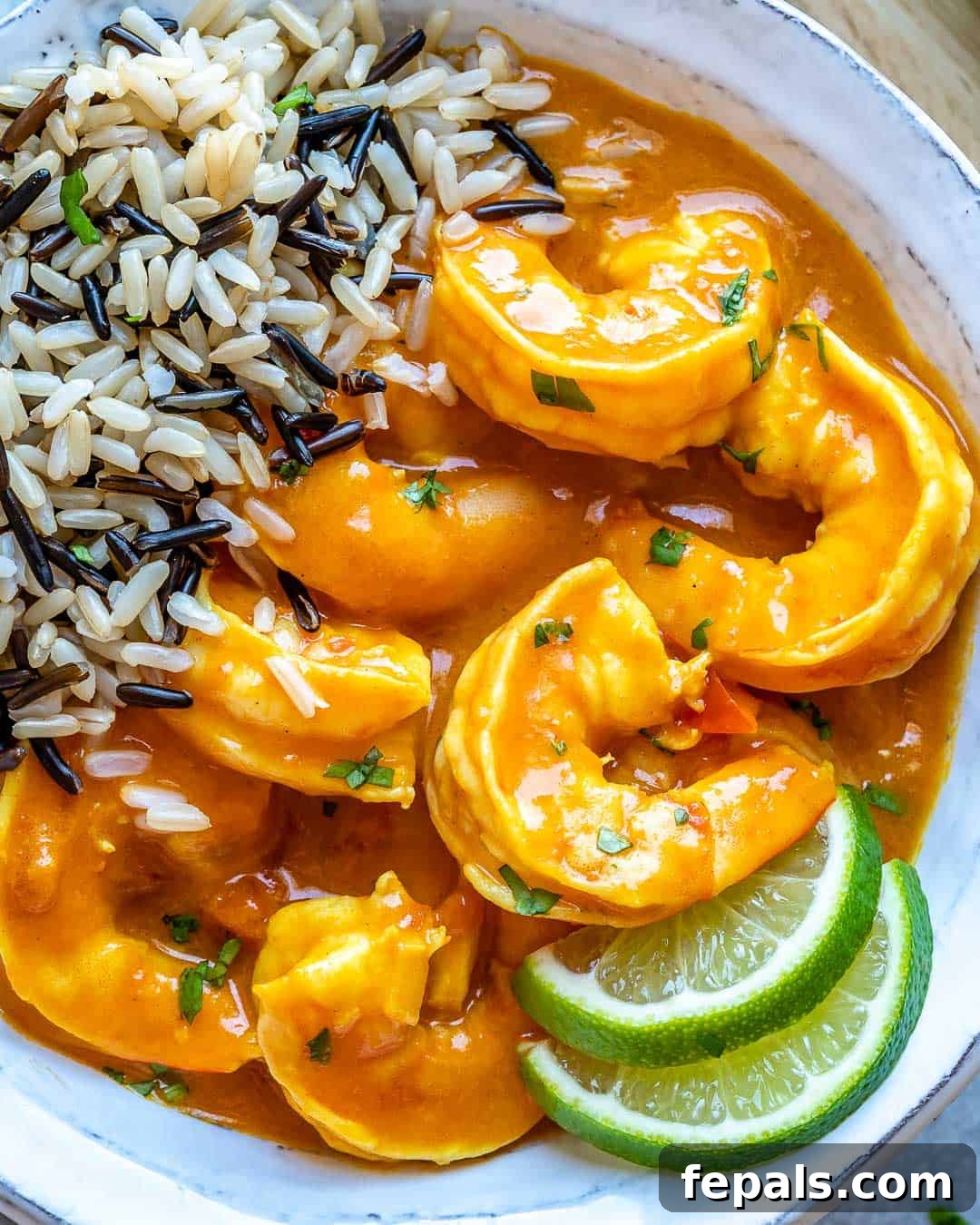 Creamy Coconut Shrimp Curry 9 Close-up view of a shrimp in a bowl of creamy shrimp curry with rice, highlighting the texture and richness
