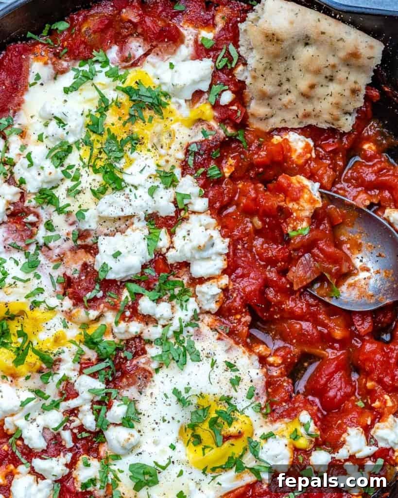 Spoon scooping easy shakshuka out of skillet. 