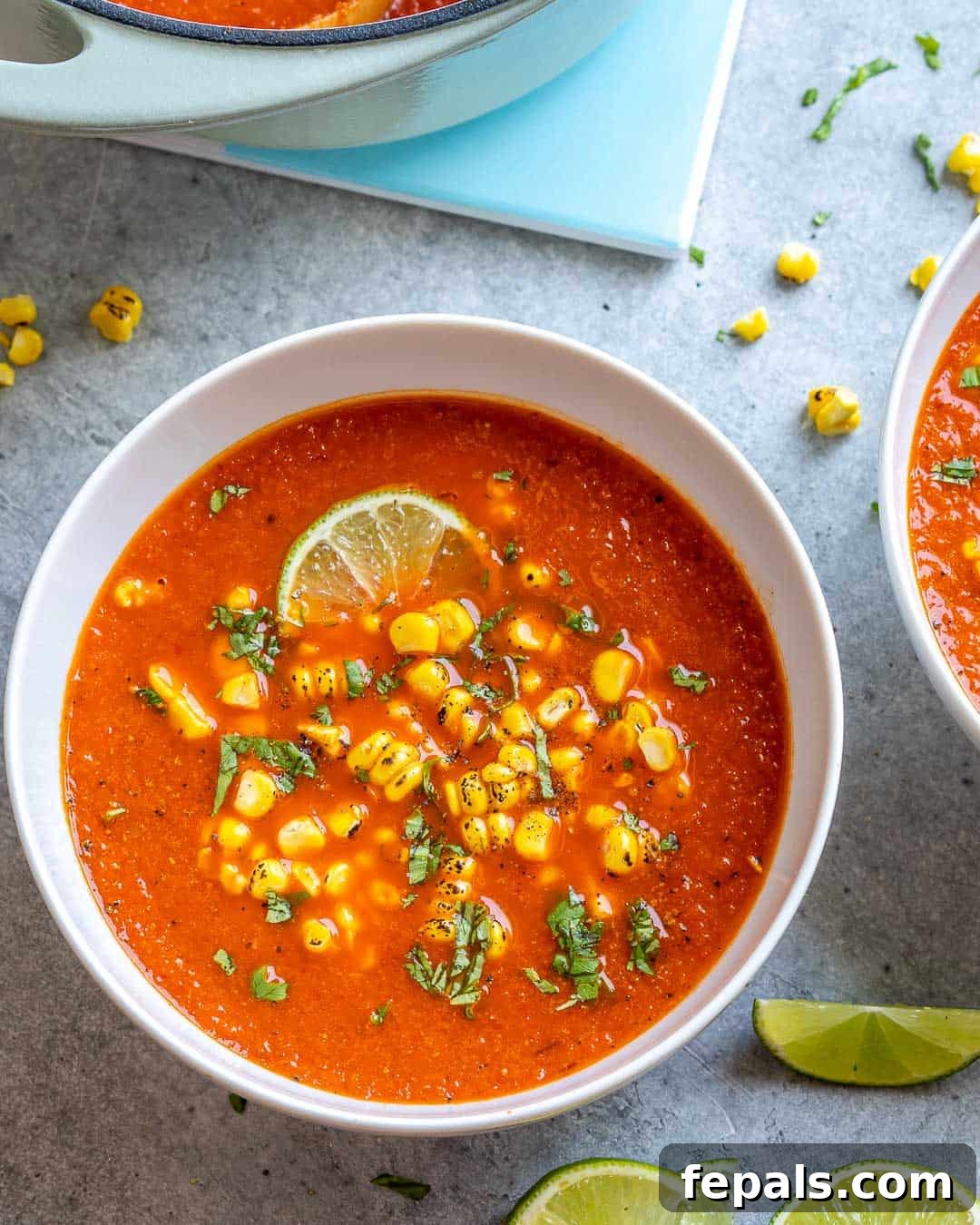 Creamy Mexican Street Corn Soup 2 A beautifully presented white bowl of Mexican Sweet Corn Soup, garnished with fresh cilantro and a lime wedge, ready to be enjoyed.
