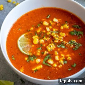 Creamy Mexican Street Corn Soup 11 one bowl of Mexican sweet corn soup topped with chopped parsley and lime wedge.