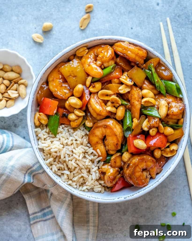 Top view of kung pao shrimp in white bowl with chop sticks