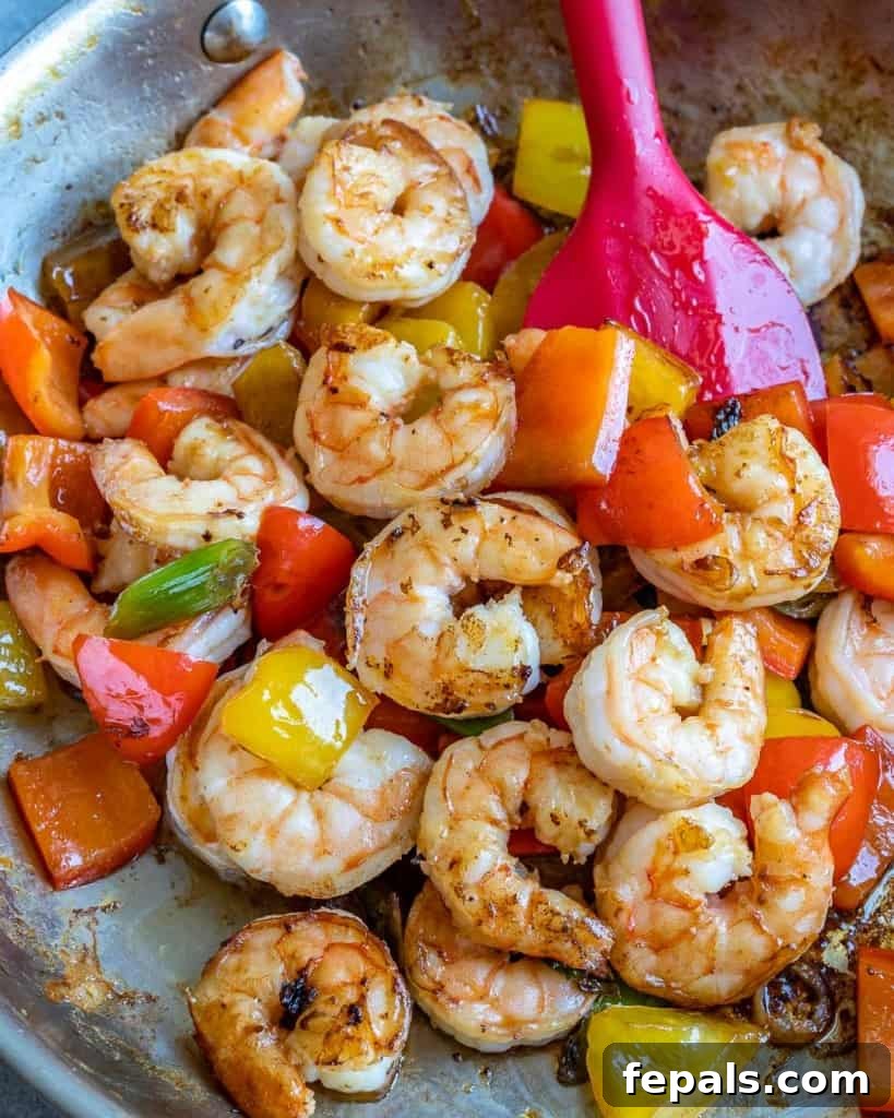 Spicy Szechuan Peanut Shrimp 4 Shrimp mixed with bell peppers and green onions in a pan, actively cooking