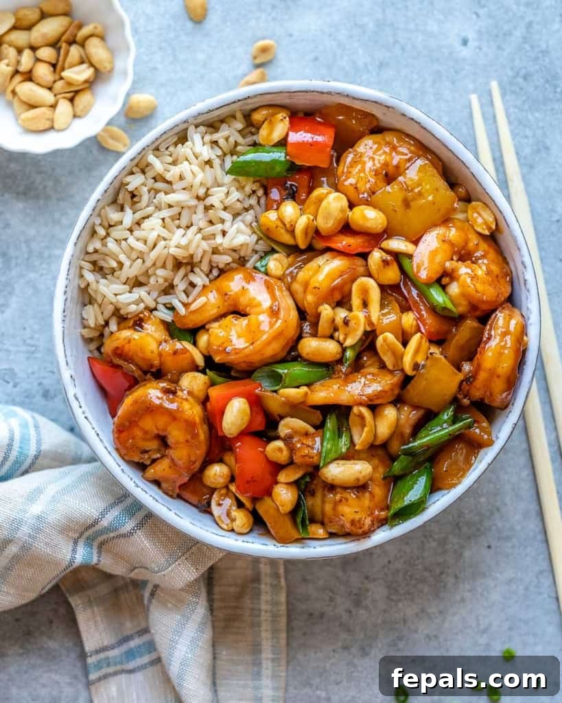 Spicy Szechuan Peanut Shrimp 7 A serving bowl filled with Kung Pao shrimp and various vegetables, accompanied by a small portion of rice