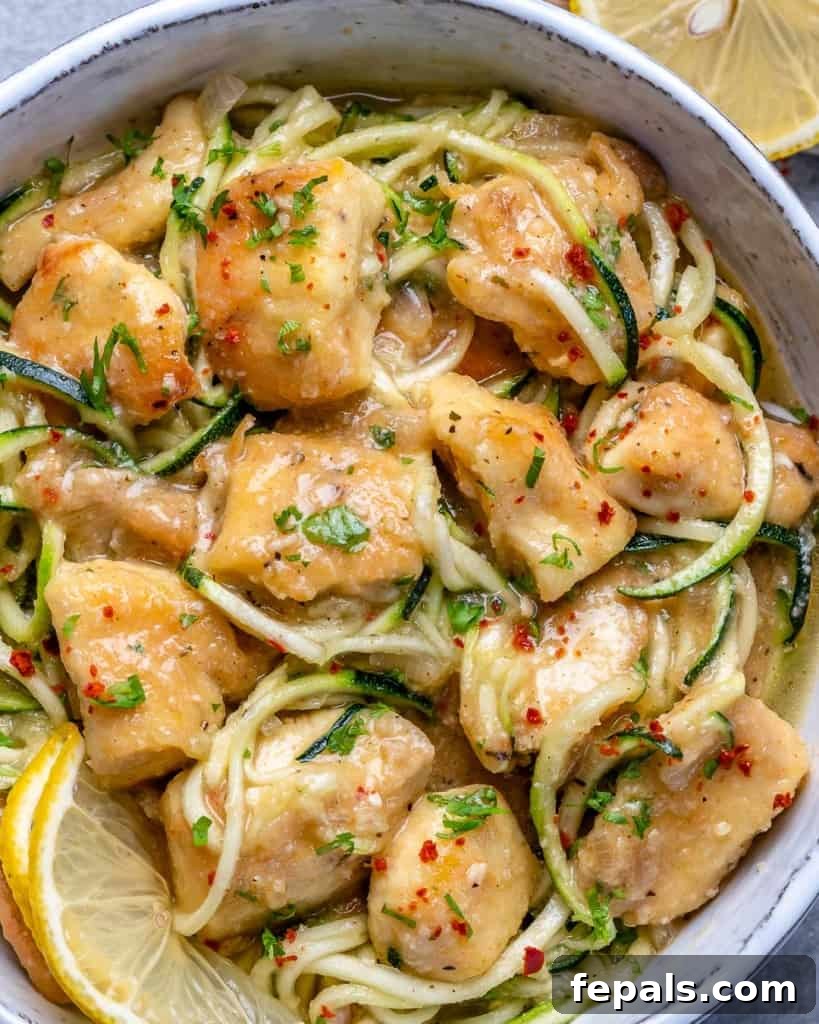 close up chicken scampi with zoodles, lemon garnish and chili pepper flakes.