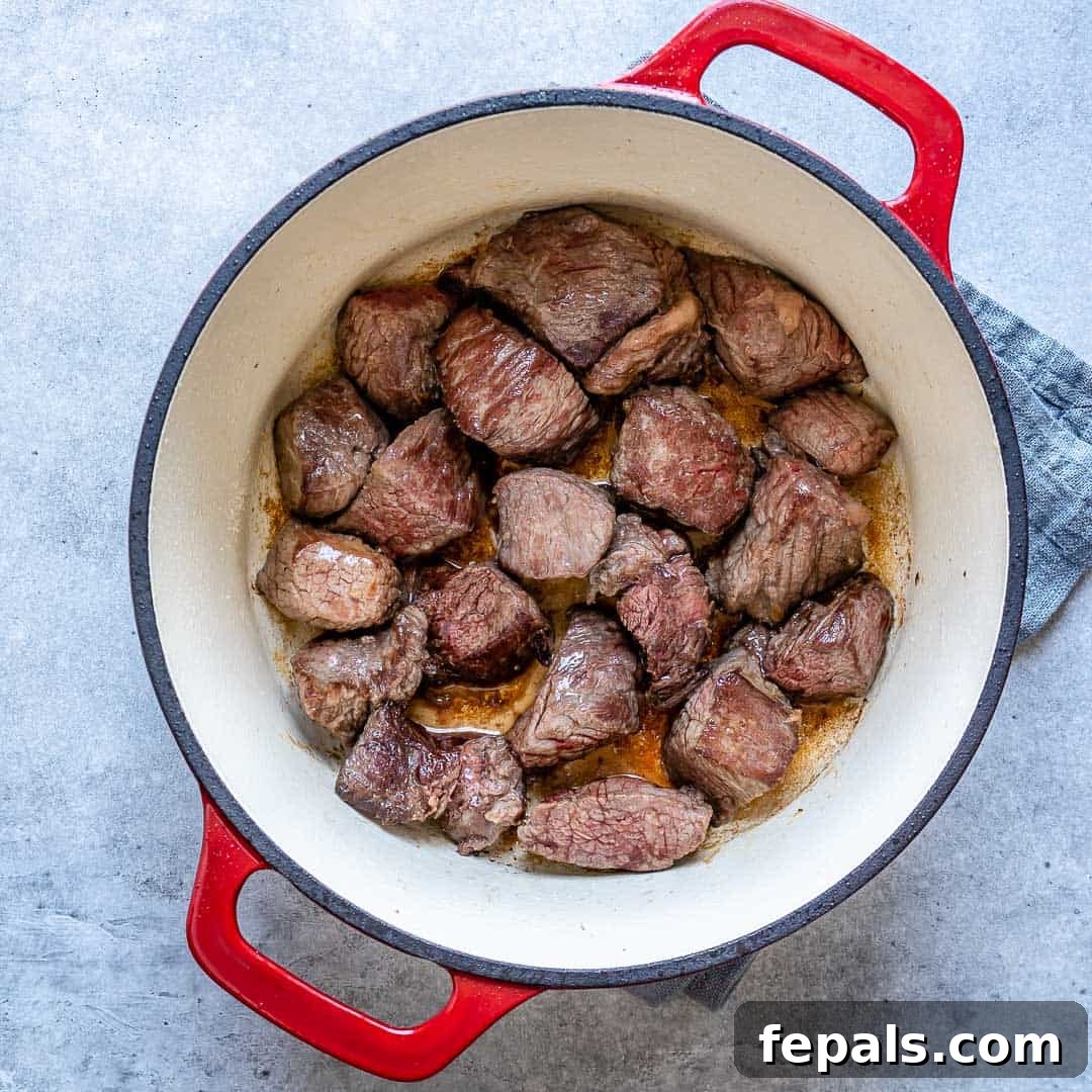 Heartwarming Beef Stroganoff Soup 6 Chunks of steak cooking in dutch oven for soup