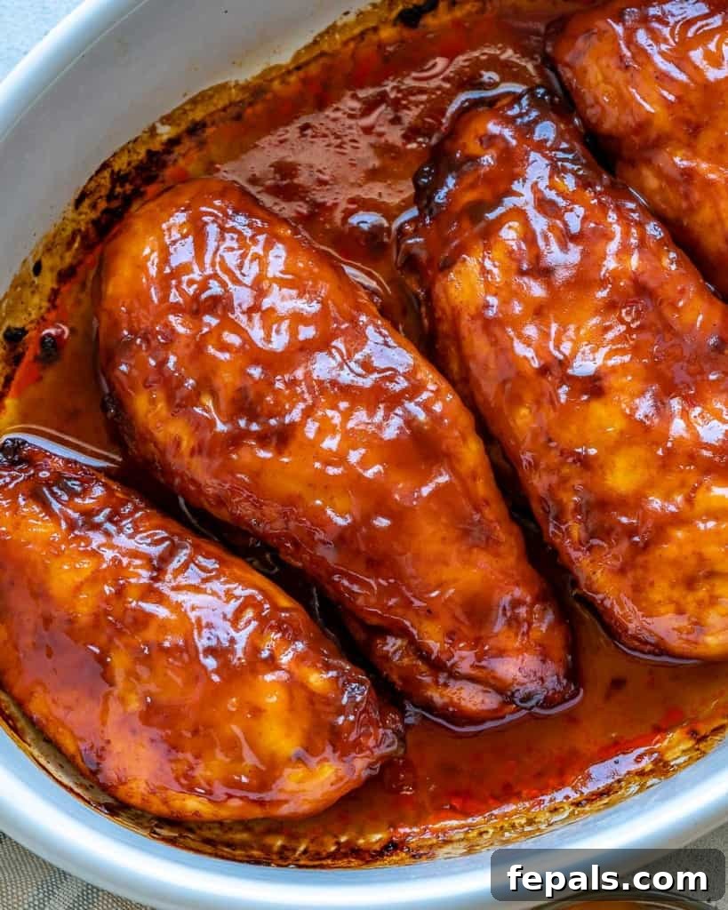 Glazed BBQ Chicken Breast 4 Top view 4 baked chicken breasts with bbq sauce in white baking dish