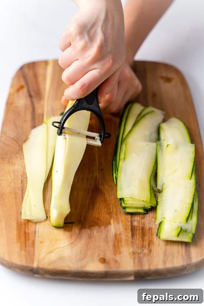 Simple Steps to Homemade Zucchini Noodles 14 a peeler expertly creating thin, uniform strips from a zucchini