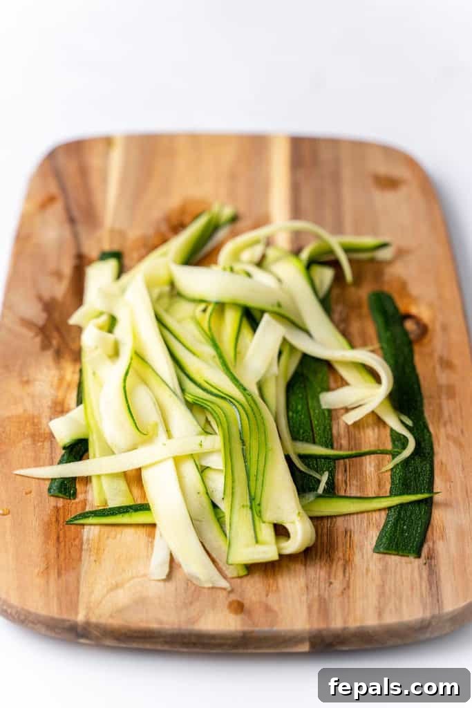 Simple Steps to Homemade Zucchini Noodles 15 finely cut zoodles neatly arranged on a wooden cutting board