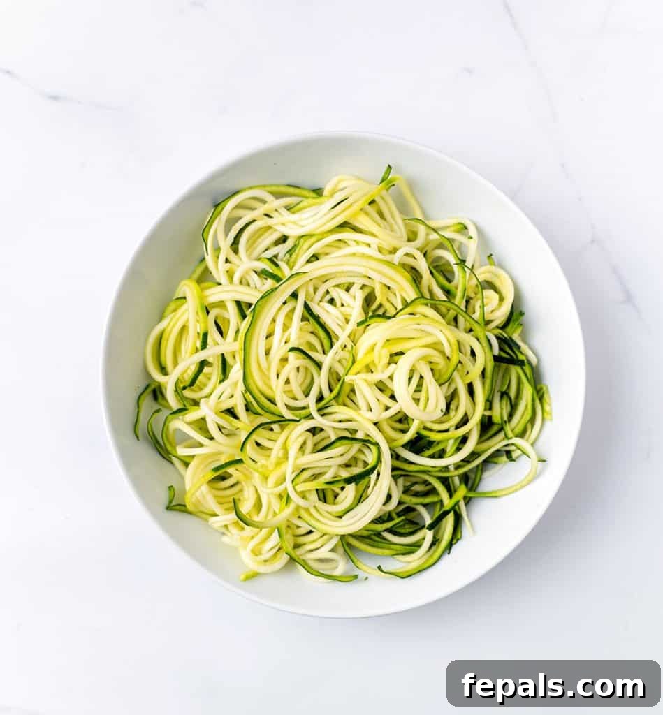 Simple Steps to Homemade Zucchini Noodles 5 top view of perfectly spiraled zoodles arranged on a white plate