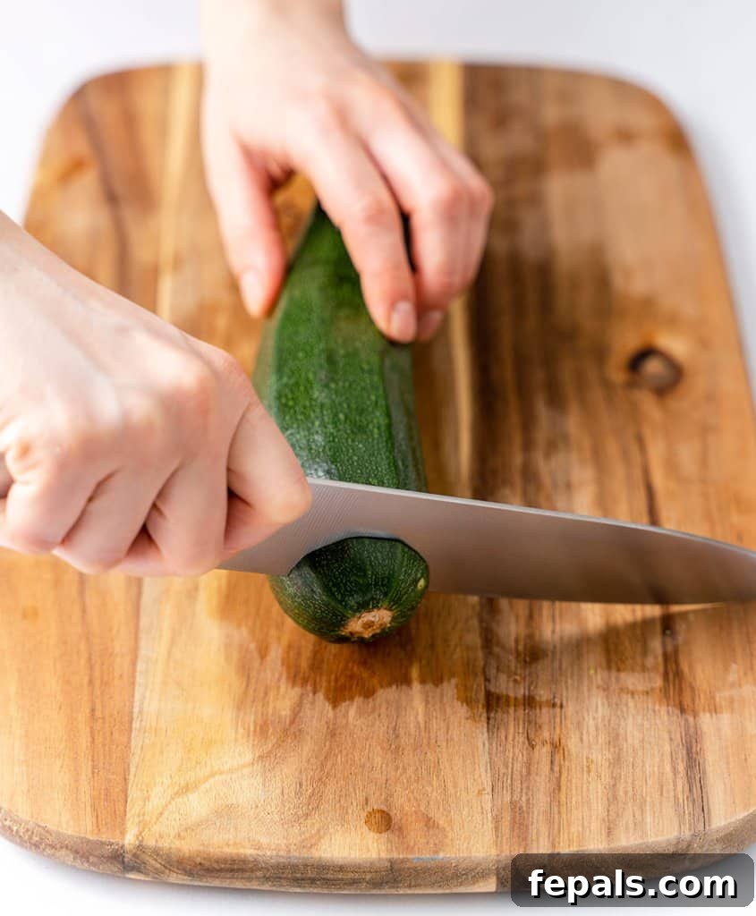 Simple Steps to Homemade Zucchini Noodles 6 knife cutting the tip of a zucchini on a wooden board