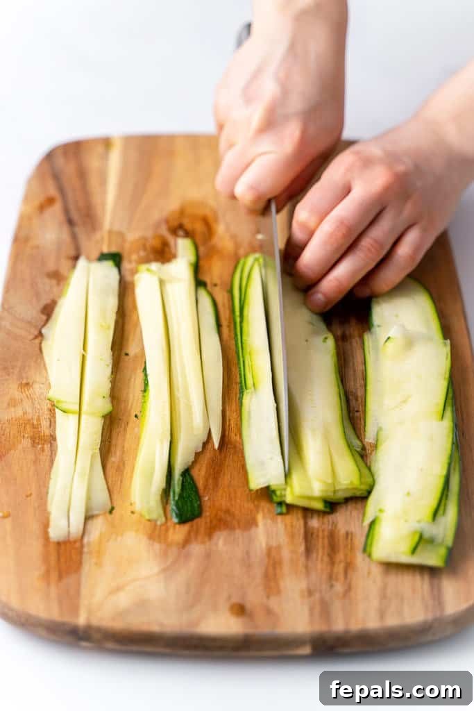Simple Steps to Homemade Zucchini Noodles 9 knife carefully cutting thin layers of zucchini into noodle shapes on a cutting board