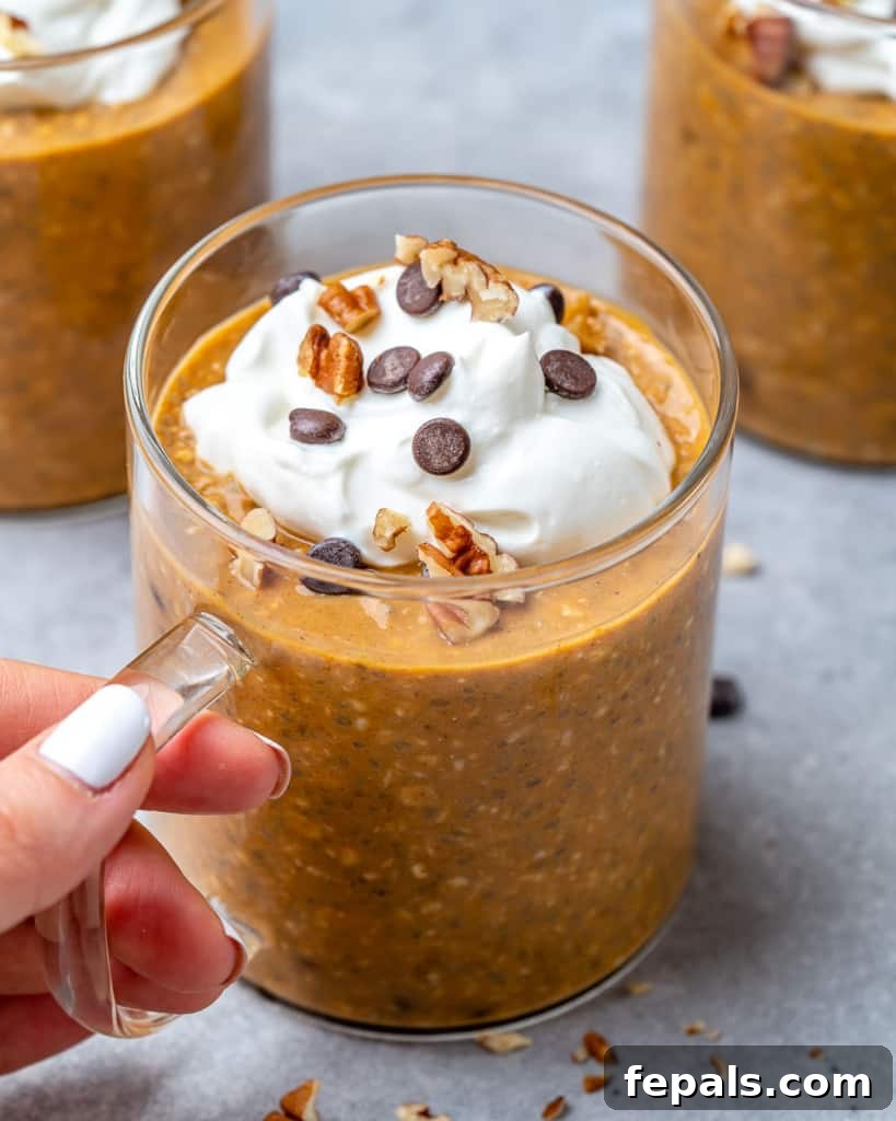 hand holding a cup of pumpkin overnight oats 
