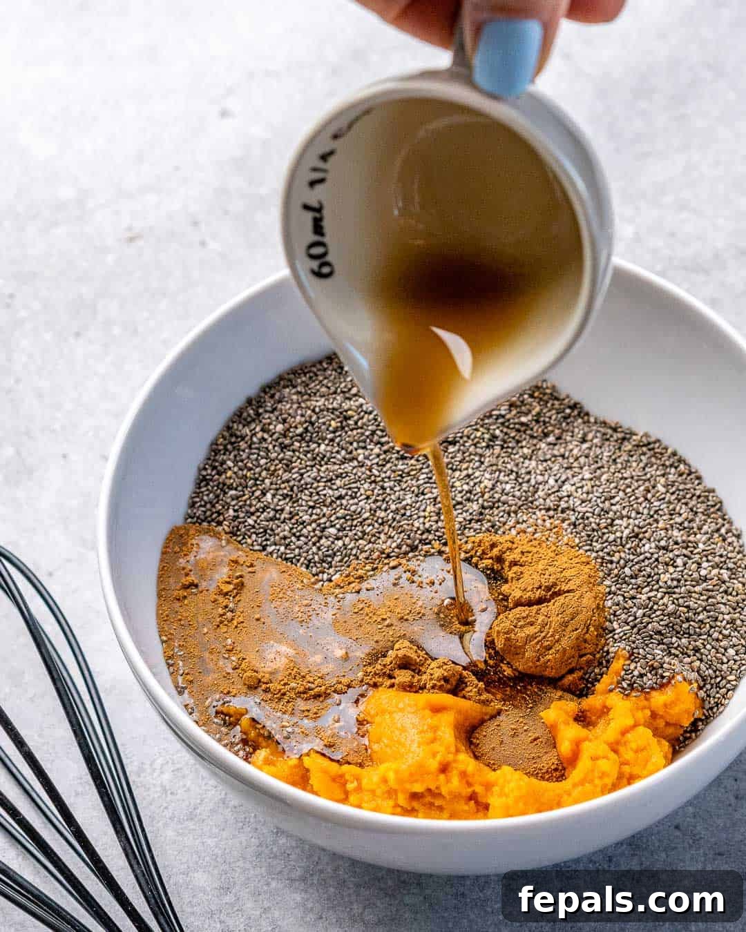 Pumpkin Spice Chia Dream 6 maple syrup being pour over pumpkin puree and chia seeds