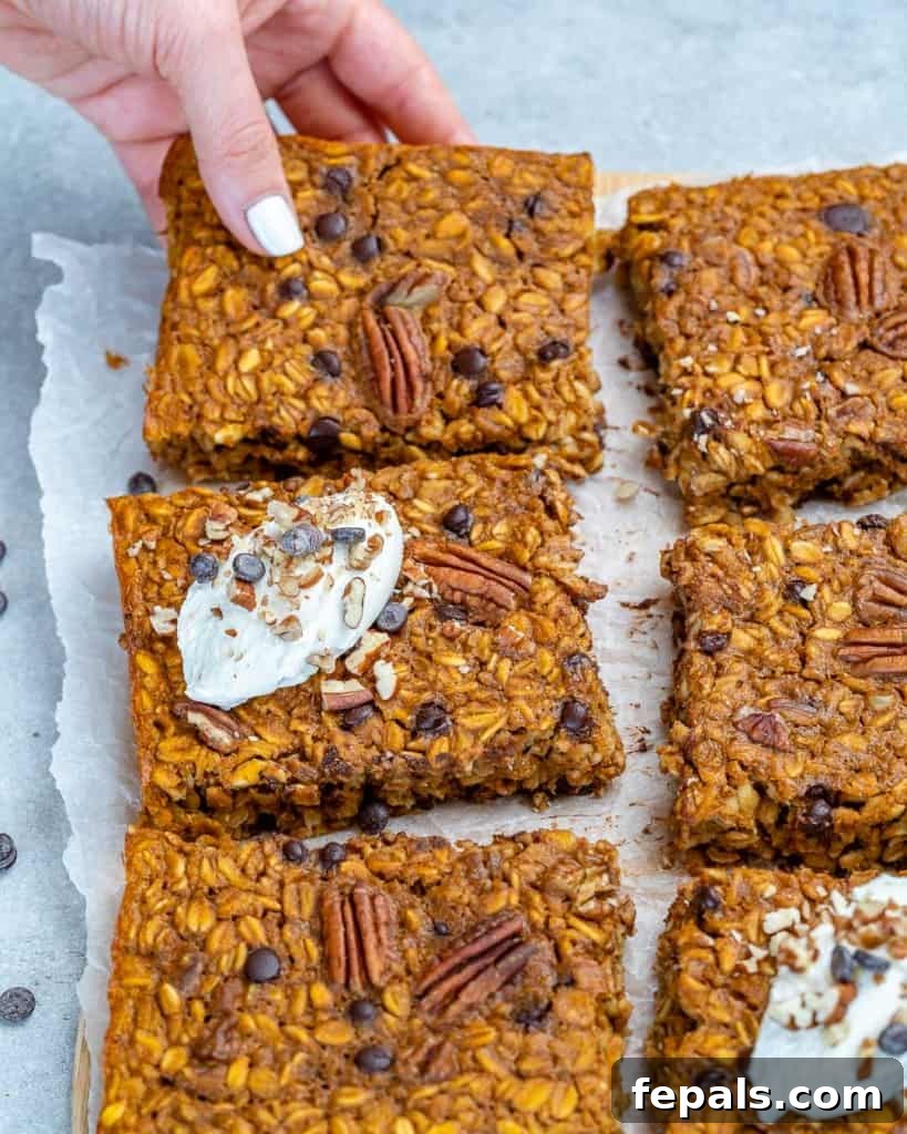 Spiced Pumpkin Chocolate Chip Breakfast Bake 7 hand reaching for one oatmeal bake square