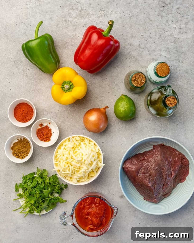 Fiesta Keto Steak Stuffed Peppers 4 Top down shot of all fresh ingredients for keto stuffed peppers laid out on a wooden board.