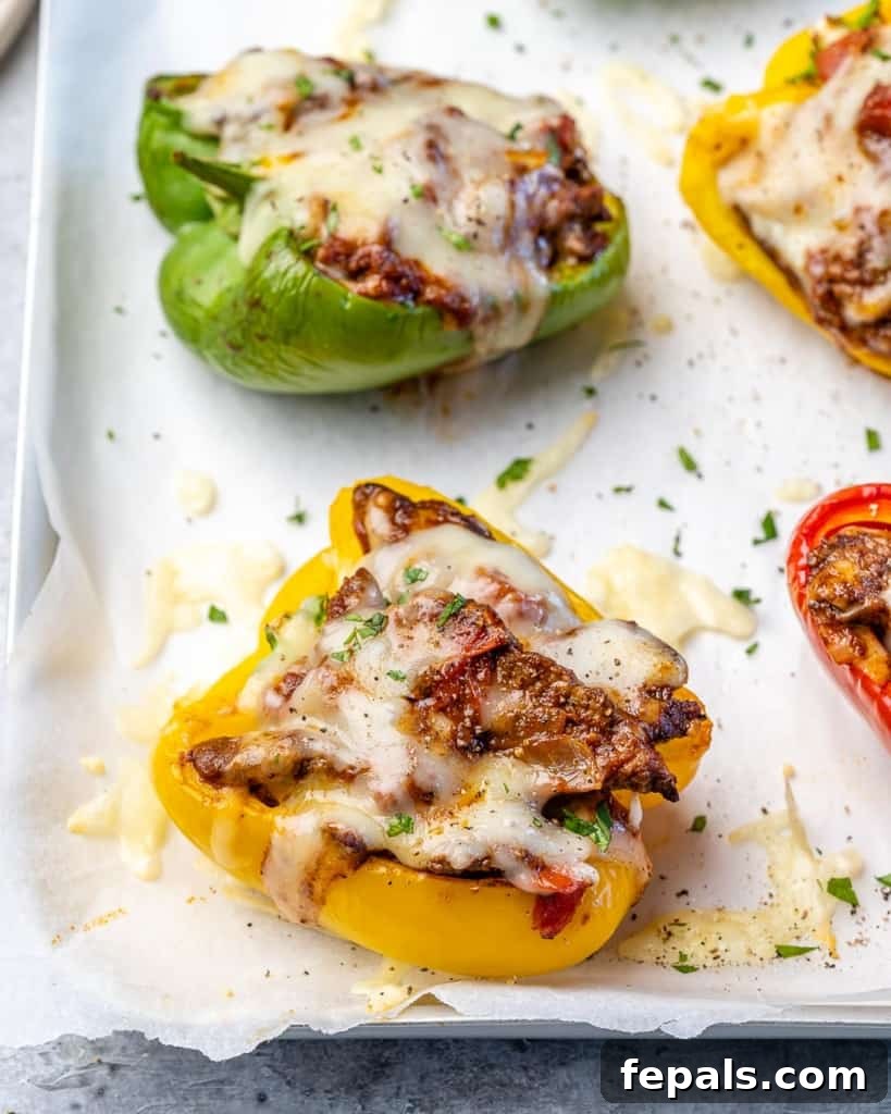 Fiesta Keto Steak Stuffed Peppers 8 Red, green, and yellow keto taco stuffed peppers beautifully arranged on a baking sheet, ready for the oven.
